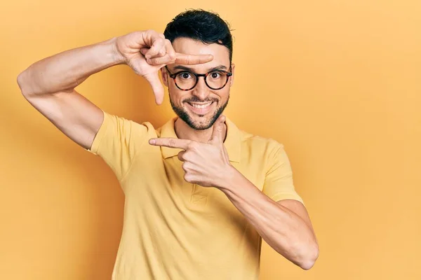 Joven Hombre Hispano Vistiendo Ropa Casual Gafas Sonrientes Haciendo Montura —  Fotos de Stock