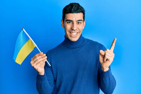 Красивый Латиноамериканец Украинским Флагом Улыбается Показывая Рукой Пальцем Сторону — стоковое фото