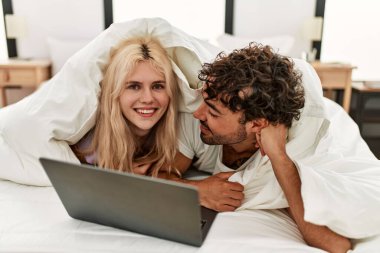 Çift dizüstü bilgisayar kullanıyor ve evde film seyrediyor..