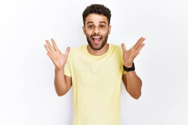 Arap genç adam arka planda durmuş çılgın ve başarıyı kollarını kaldırıp heyecanla haykırarak kutluyor. Kazanan konsept 