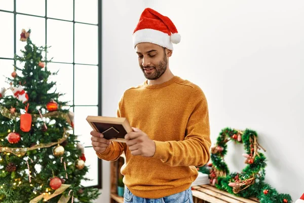 Young Arab Man Holding Frame Standing Christmas Tree Home — Stock Photo, Image