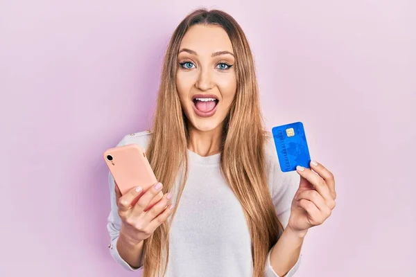 Młoda Blondynka Trzyma Smartfon Kartę Kredytową Świętując Szalony Zdumiony Sukcesem — Zdjęcie stockowe