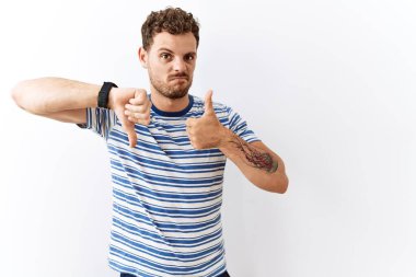 Tecrit edilmiş arka planda duran yakışıklı genç adam onay veriyor, anlaşmazlık ve uzlaşma ifadesi sergiliyor. çılgın çatışma 