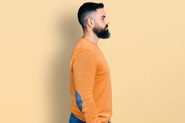 Sakallı, sıradan bir süveter giyen, rahat bir görünüm takınan, doğal yüzlü ve kendine güvenen bir gülümseme takınan İspanyol bir adam.. 
