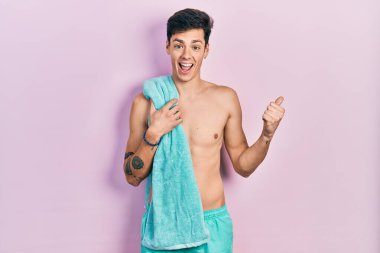 Mayo ve havlu giymiş, ağzı açık gülümseyen genç bir İspanyol. 