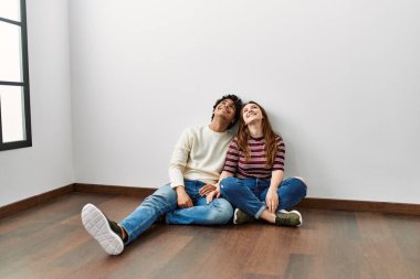 Genç İspanyol çift tavana bakıyor. Boş bir evde yerde oturuyorlar..