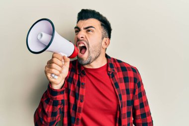 Sakallı İspanyol adam megafonla bağırıyor.