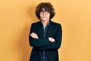 İş ceketi ve gözlük takan yakışıklı genç adam şüpheci ve gergin. Yüzünde çapraz kollu tasvip etmeyen bir ifade. negatif kişi. 