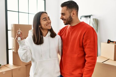 Genç İspanyol çift gülümsüyor mutlu bir şekilde yeni evin anahtarını tutuyor..