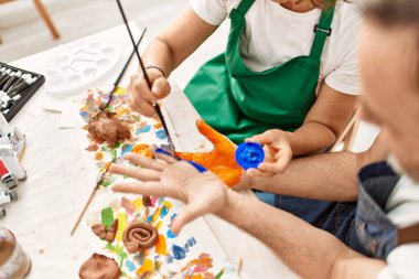 Sanat stüdyosunda mutlu mesut resim yapan iki orta yaşlı öğrenci..