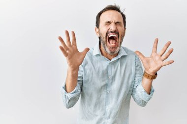 Orta yaşlı, sakallı İspanyol bir adam izole edilmiş arka planda duruyor. Kollarını kaldırmış ve gözleri kapalı heyecanla haykırarak başarının çılgınlığını kutluyor. Kazanan konsept 