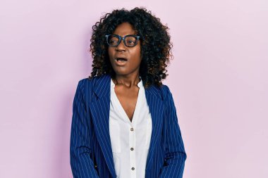 Genç Afro-Amerikalı kadın iş kıyafetleri ve gözlük takıyor kızgın ve kızgın çığlıklar atıyor sinirli ve öfkeli, öfkeyle bağırıyor. öfke ve agresif konsept. 