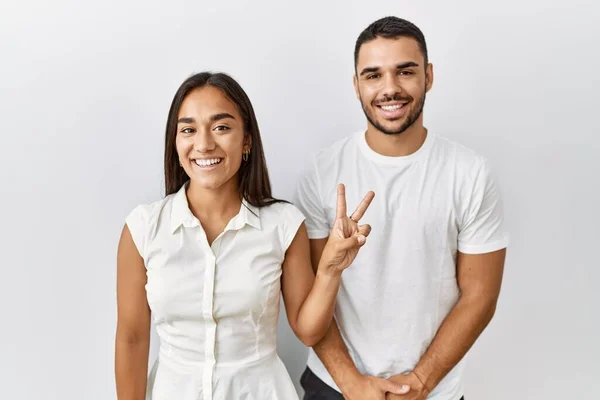 一对年轻的跨种族夫妇在孤独的背景下相爱地站在一起 带着第二指尖 带着自信和快乐的笑容 — 图库照片