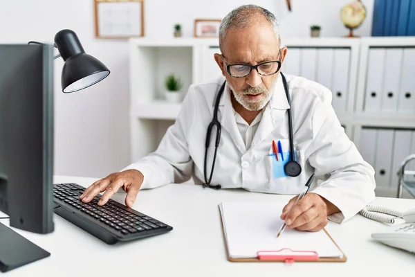 Starszy Siwowłosy Mężczyzna Mundurze Lekarza Pracujący Klinice — Zdjęcie stockowe
