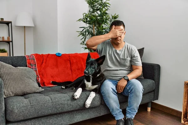 Jovem Latino Homem Cão Sentado Sofá Casa Cobrindo Olhos Com — Fotografia de Stock