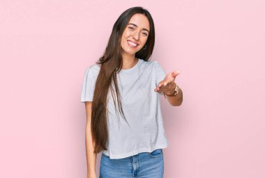 Gündelik beyaz tişört giyen, neşeli gülümseyen, yardım eli uzatan ve kabul gören genç İspanyol kız.. 