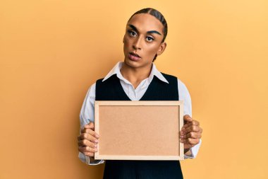 Makyaj yapan, uzun saçlı, şaşkın suratlı, ağzı açık, şüpheci ve alaycı görünen İspanyol bir adam. 