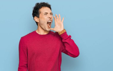 Sıradan kıyafetler giyen genç yakışıklı adam el ele verip bağırarak ve yüksek sesle bağırıyor. iletişim konsepti. 