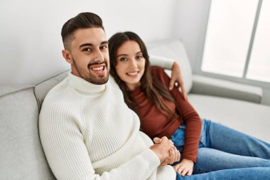 Genç İspanyol çift kanepede ve evde sarılıp dinleniyorlar..