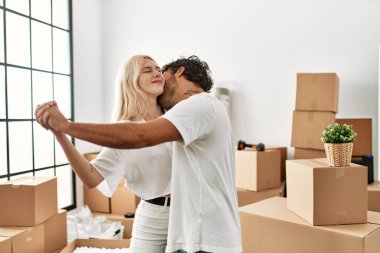 Genç ve güzel bir çift yeni evinde mutlu bir şekilde dans ediyor.