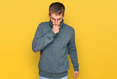 Sıradan kıyafetler giyen genç sarışın adam kendini iyi hissetmiyor ve soğuk algınlığı veya bronşitin belirtisi olarak öksürüyor. sağlık hizmeti kavramı. 