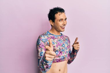 Makyaj elbisesi giymiş yakışıklı bir adam kamerayı mutlu ve komik suratıyla işaret ediyor. iyi enerji ve titreşimler. 