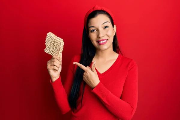 Ung Latinamerikansk Kvinna Håller Okokt Nudlar Ler Glad Pekar Med — Stockfoto