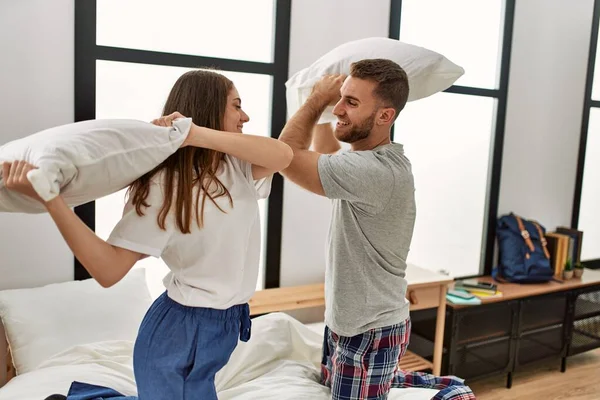 Unga Kaukasiska Par Ler Glada Slåss Med Kuddar Sängen Hemma — Stockfoto