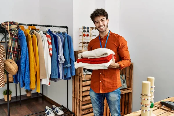 Jovem Lojista Hispânico Homem Sorrindo Feliz Segurando Pilha Suéter Loja — Fotografia de Stock