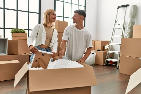 Jovem Casal Caucasiano Sorrindo Feliz Unboxing Caixa Papelão Nova Casa — Fotografia de Stock