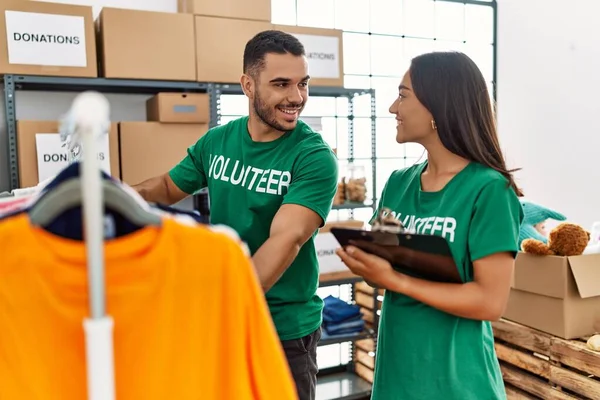 Young Latin Volunteer Couple Smiling Happy Holding Clipboard Charity Center — Stock Photo, Image