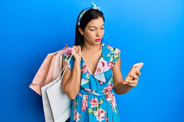 Mladá Latinská Žena Držící Nákupní Tašky Smartphone Uvolnila Vážným Výrazem — Stock fotografie