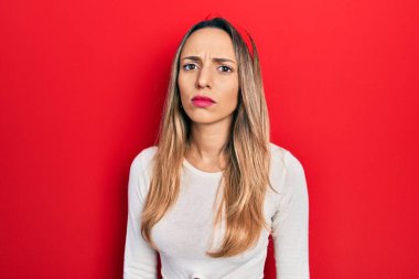 Güzel İspanyol kadın, kırmızı diyadem kuşkucu ve gergin giyiniyor, sorun yüzünden kaşlarını çatıyor. negatif kişi. 