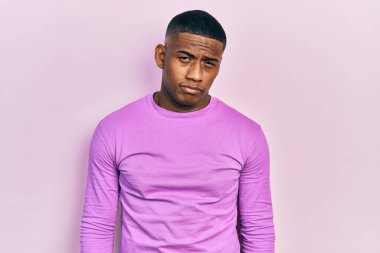 Genç siyah bir adam, günlük pembe kazak giyiyor. Depresyonda ve endişe içinde. Kızgın ve korkmuş bir şekilde ağlıyor. hüzünlü ifade. 