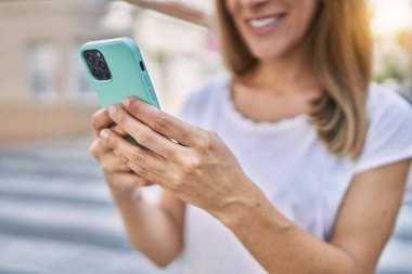 Sokakta akıllı telefon kullanan, kendine güvenen genç İspanyol kadın.