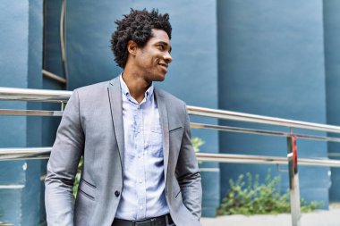 Genç Afrikalı Amerikalı iş adamı şehirde mutlu mesut dikiliyor..