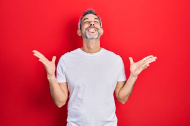 Yakışıklı, orta yaşlı, gri saçlı, sıradan beyaz tişörtlü, başarıyı kutlayan kolları havada ve gözleri kapalı heyecanlı bir adam. Kazanan konsept 