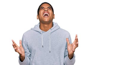 Genç, yakışıklı, sıradan bir tişört giyen çılgın ve deli gibi bağıran saldırgan bir ifade ve kollarla bağıran bir İspanyol. hüsran kavramı. 