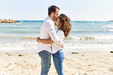 Orta yaşlı İspanyol çift sahilde öpüşüyor ve sarılıyorlar..