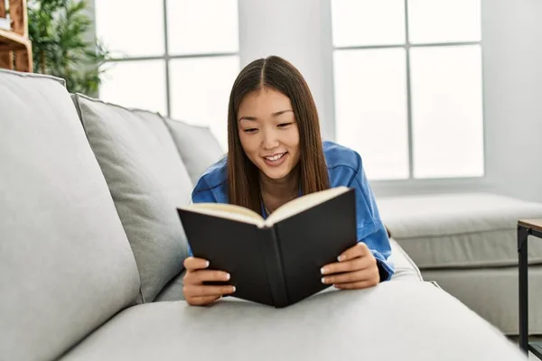 Ung Kinesisk Flicka Läser Bok Liggande Soffan Hemma — Stockfoto