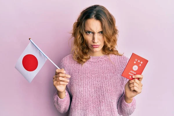 Mujer Caucásica Joven Con Bandera Japón Pasaporte Escéptico Nervioso Frunciendo —  Fotos de Stock