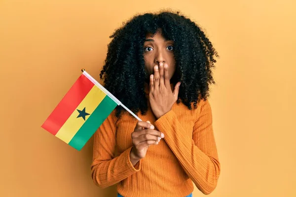 Africká Američanka Afro Vlasy Držící Ghanskou Vlajku Ústech Rukou Šokovaná — Stock fotografie