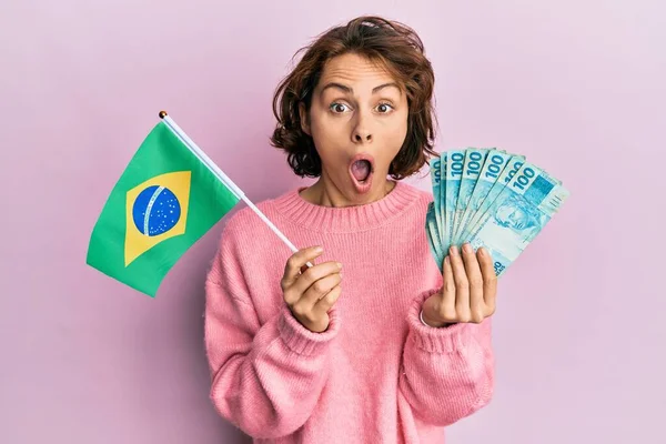 Joven Morena Sosteniendo Bandera Brasileña Billetes Reales Asustada Sorprendida Con —  Fotos de Stock