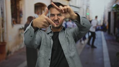 Genç İspanyol asıllı bir adam, şehir sokaklarında hareketli bir el hareketleriyle fotoğraf sanatında yaratıcılığını ve hareketliliğini gösteriyor..