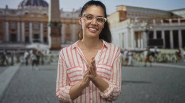 Gözlüklü ve çizgili tişörtlü genç İspanyol kadın Vatikan 'da el çırpıyor; sevinç kutlamaları.