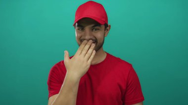 Kırmızı şapkalı ve tişörtlü İspanyol genç adam ağız üstüne stüdyo, neşeli bir hareketle gülümsüyor; sessizlik..