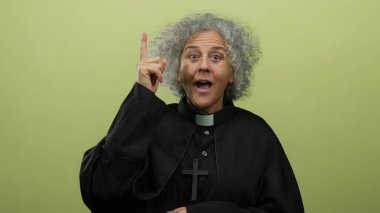 Dini giyinmiş yaşlı gri saçlı kadın, ilham ve bilgeliği ifade eden sarı arkaplana karşı fikir beyan eder..