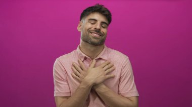 Stüdyoda İspanyol erkek debriyajı seti, kapalı gözler ve pembe ışık altında hafif bir gülümseme..