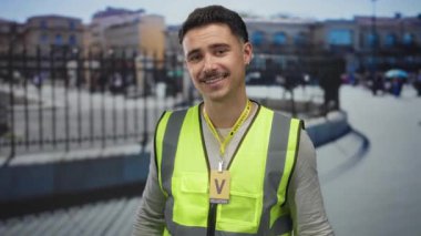 Yansıtıcı yelek giyen genç İspanyol adam şehir sokaklarında gönüllü olarak çalışıyor. Şehir dışında kamu hizmeti faaliyetlerine katılıyor.