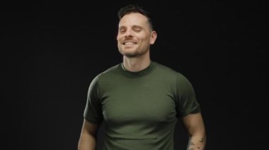 Genç adam, özgüvenle gülümsüyor, cazibesini ve çekiciliğini somutlaştırıyor ve tavırlarında bir nebze de olsa oyunculuk seziyor..